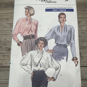May include: Vogue Patterns sewing pattern 7645. The pattern features illustrations of women's blouses with draped necklines. The cover includes the text "Vogue Patterns", "EASY / FACILE", and the size "10".