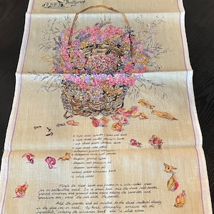 May include: A beige linen tea towel with a floral illustration of a basket filled with lavender and roses. The text "Pot-pourri" is printed in purple at the top of the towel. The recipe for potpourri is printed below the illustration, including ingredients like dried lavender flowers and leaves, dried lemon verbena leaves, dried rose petals, ground cinnamon, orris root powder, ground cloves, rose geranium oil, lavender oil, cinnamon bark, and whole cloves.