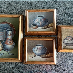 May include: Set of four framed paintings depicting Native American pottery. Each painting features a different style of pottery, with intricate designs and colors. The paintings are framed in wood with a rustic finish.