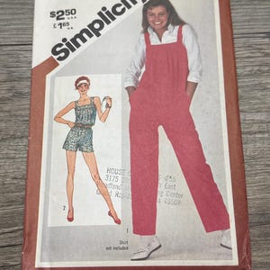 Peut inclure: Patron de couture Simplicity vintage, taille 16, présentant une combinaison rouge et un short. La couverture comprend des illustrations des vêtements et le logo Simplicity. La chemise n'est pas incluse.