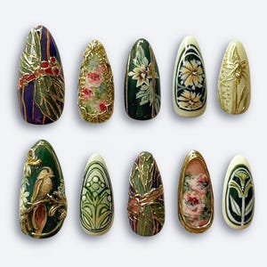 May include: A collection of ten almond-shaped, painted fingernails. Each nail features intricate designs, including floral patterns, birds, and gold accents. The color palette includes deep greens, purples, and creams, creating a vintage aesthetic.