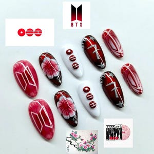 May include: Artificial nails with diverse designs. Some nails display a red and white logo, others feature floral patterns, and some have a silver design on a dark red base. The image also includes the BTS logo and a group photo.