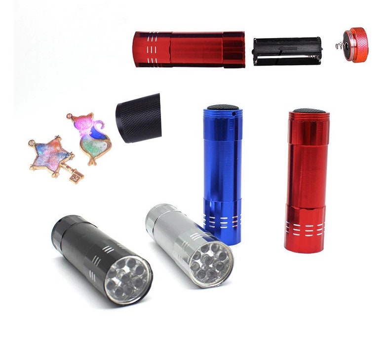 May include: Four flashlights with different colored bodies: red, blue, silver, and black. Each flashlight has a clear lens with multiple LED lights visible inside. The flashlights are on a white background.
