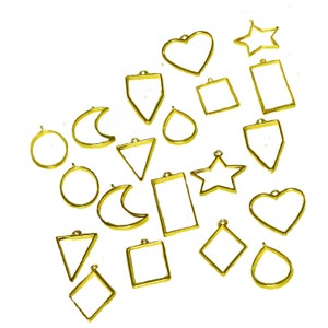 May include: A set of 18 gold-toned metal pendant trays in various shapes, including hearts, stars, moons, circles, and geometric shapes. The trays are designed for resin casting and jewellery making.