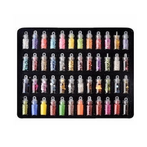 May include: A set of 48 small glass bottles filled with colorful glitter. The bottles are arranged in a black tray with a white background.