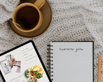 Peut inclure: Une composition à plat avec une tasse de thé jaune sur une soucoupe marron, une tablette numérique, un carnet à spirales et un stylo. La tablette affiche des images et du texte en français. Le carnet porte l'inscription "summer glow".