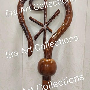 May include: A wooden staff with a Chi Rho symbol at the top. The staff is a rich brown color with a glossy finish. The text "Era Art Collections" is watermarked on the image.