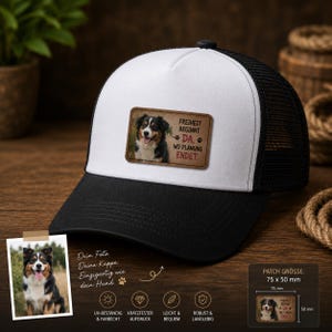 Könnte beinhalten: Eine weiß-schwarze Trucker-Cap mit einem rechteckigen Aufnäher, der einen Australian Shepherd und den Text FREIHEIT BEGINNT DA, WO PLANUNG ENDET zeigt. Die Kappe hat eine weiße Vorderseite, einen schwarzen Schirm und ein schwarzes Netzgewebe.