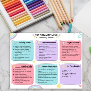May include: A colorful print titled "The Dopamine Menu" with a pastel rainbow design. The menu lists sensory snacks, quick movement, digital rewards, creative hits, connection & care, and favorite boosts. Colored pencils and pastels are in the background.
