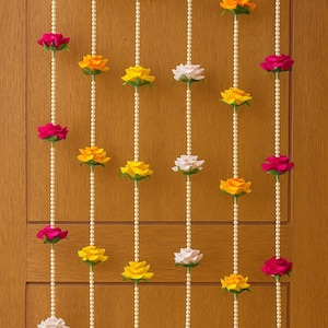 May include: Decorative floral garland featuring alternating strands of colorful roses in shades of pink, yellow, orange, and white. The flowers are strung on pearl-like strands, creating a festive and elegant look. Perfect for home decor or special events.