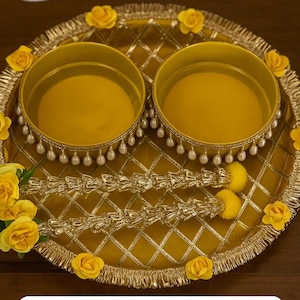 Op de afbeelding: Een decoratief geel dienblad met twee ronde bakjes. De lade is versierd met gouden randen, een ruitpatroon en gele rozen. De bakjes hebben parelaccenten.
