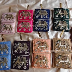 May include: A collection of colorful, rectangular, small purses with a flap closure. Each purse features an embroidered elephant design with gold and silver accents. The purses come in various colors, including pink, blue, and green.