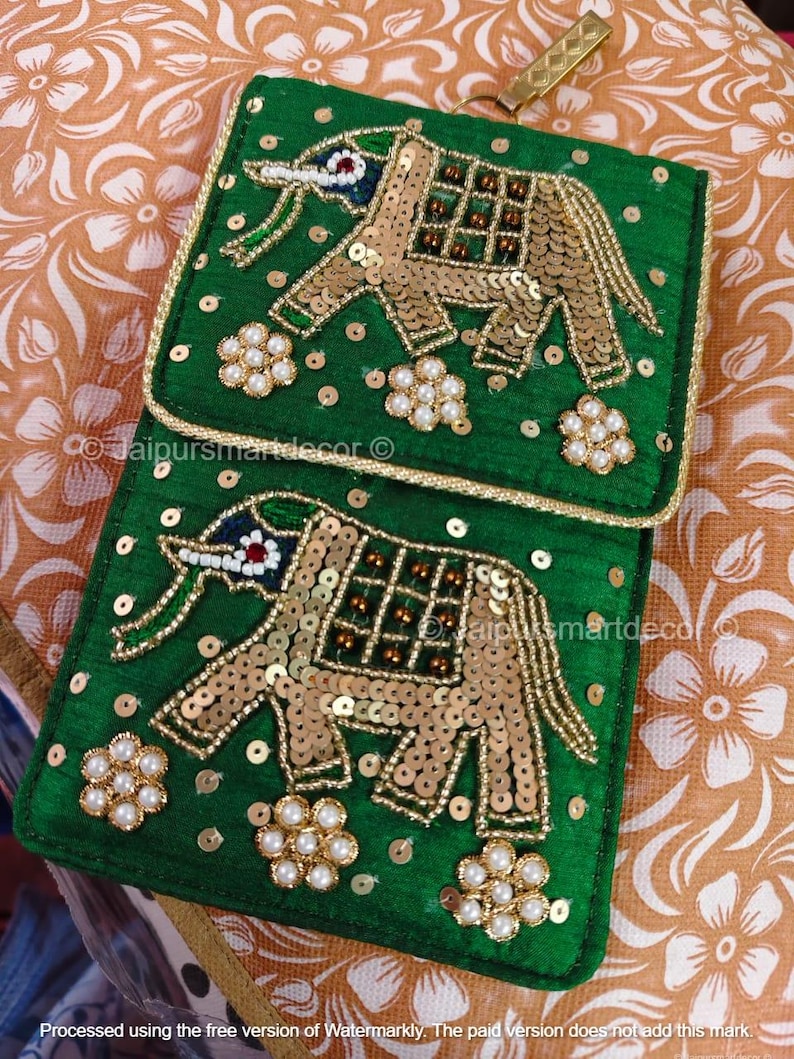 May include: Two green, rectangular, embroidered pouches with gold elephant designs. The elephants are embellished with gold sequins and beads. The pouches have a gold trim and are decorated with pearl-like flower clusters.
