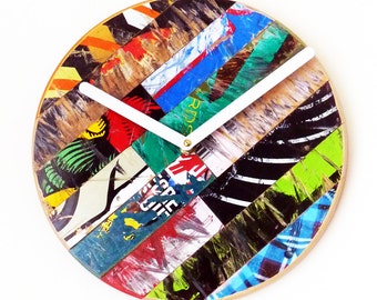 May include: A round clock with white hands and a face made of colorful, patterned skateboard deck pieces.