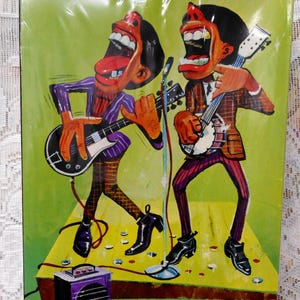 May include: A vintage box featuring a cartoon illustration of two musicians playing instruments. The box has text that reads "Hawk" and "Steel Pluckers" with other text. The background is green and black.