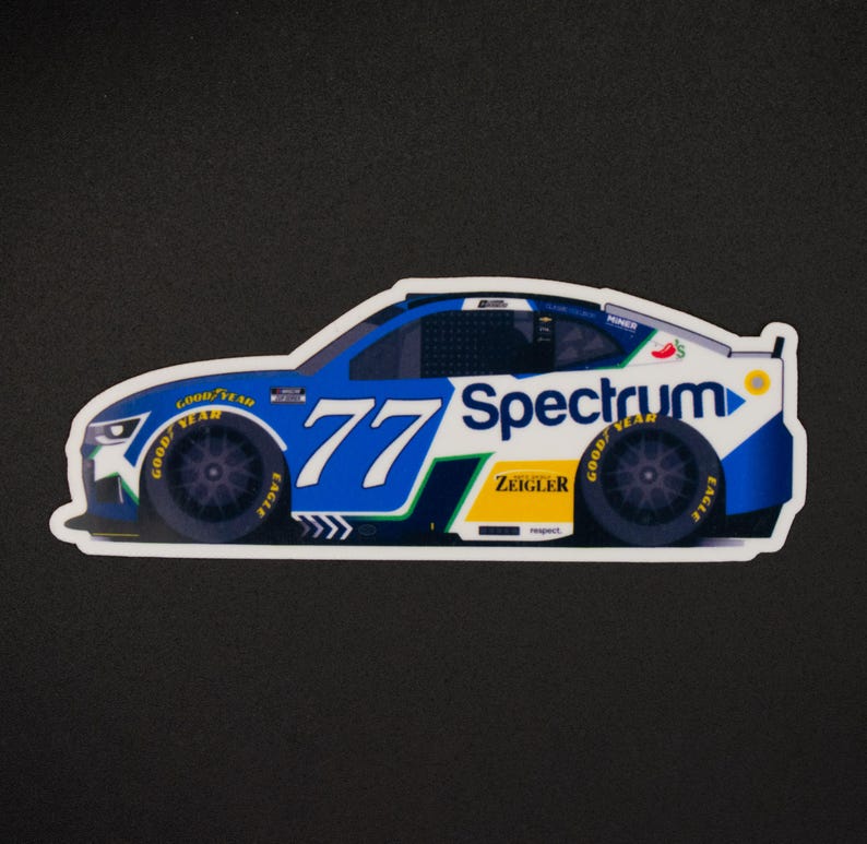 May include: A sticker depicting a race car with the number 77 in blue and white. The car has sponsor logos, including "Spectrum" and "Goodyear." The car is mainly blue, white, and green, with black tyres.