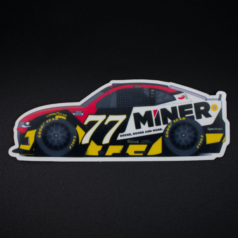 May include: A sticker depicting a race car in black, red, and white. The number "77" is in yellow, and the word "MINER" is displayed prominently. The design includes sponsor logos and the text "DOCKS, DOORS AND MORE."