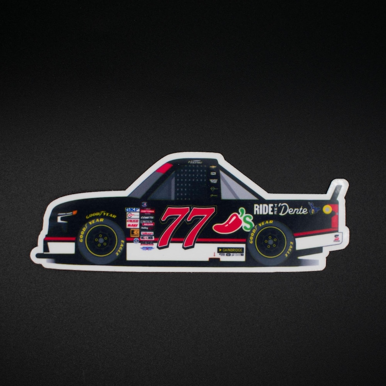 May include: A die-cut sticker of a black race car with the number 77 in white and red. The car has yellow wheels and the text "RIDE Dente" and a chili pepper graphic.