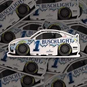 May include: A white sticker featuring a stylized race car with the number 1 and the words "BUSCH LIGHT" in blue. The car has black wheels with "GOOD YEAR" and "EAGLE" branding. Additional text includes "JOCKEY" and "MOOSE Kubota".
