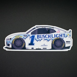 May include: A white sticker featuring a race car design with the Busch Light logo and the number 1 in blue. The car has Goodyear tires and sponsor logos, with a mountain range design.