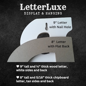 Op de afbeelding: Twee houten letters, een van 23 cm hoog en 1,3 cm dik met een spijkergat, en een van 20 cm hoog en 0,8 cm dik met een platte achterkant. De 23 cm hoge letter is wit en de 20 cm hoge letter is beige.