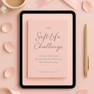 May include: A soft pink book titled "The Soft Life Challenge" with a gold pen, a cup of coffee, and a pink bow on a pink background. The book's subtitle reads "A 30-Day Challenge to Romanticize Your Routine & Reset Your Energy."