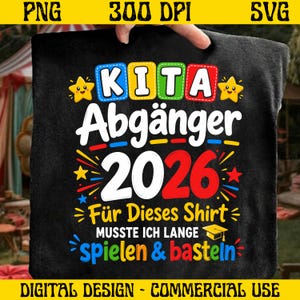 May include: Black t-shirt with a colourful design. The text reads "KITA Abgänger 2026" in white, blue, yellow, and red. Additional text says "Für Dieses Shirt MUSSTE ICH LANGE spielen & basteln". The design includes stars and a graduation cap.