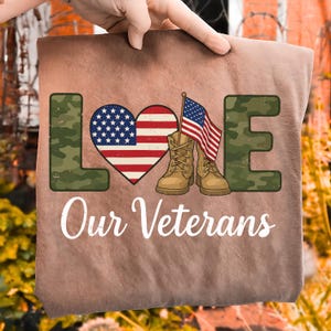 SVG PNG de "Ama a nuestros veteranos", diseño de botas con corazón de camuflaje patriótico, descarga digital de agradecimiento militar, diseño de camiseta de veterano