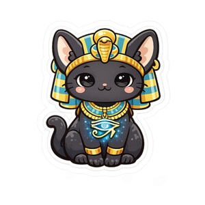 May include: A sticker featuring a black cat wearing a gold and blue Egyptian-style headdress and collar. The cat has large dark eyes, pink cheeks, and a glowing blue Eye of Horus symbol on its chest, surrounded by a subtle sparkling effect.