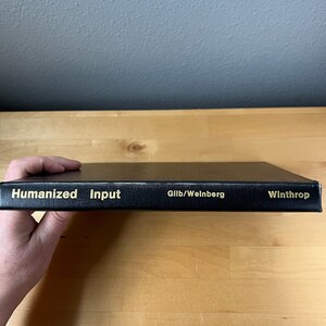 May include: Black book with gold lettering on the spine. The title is "Humanized Input" by Gilb/Weinberg. The book is published by Winthrop.