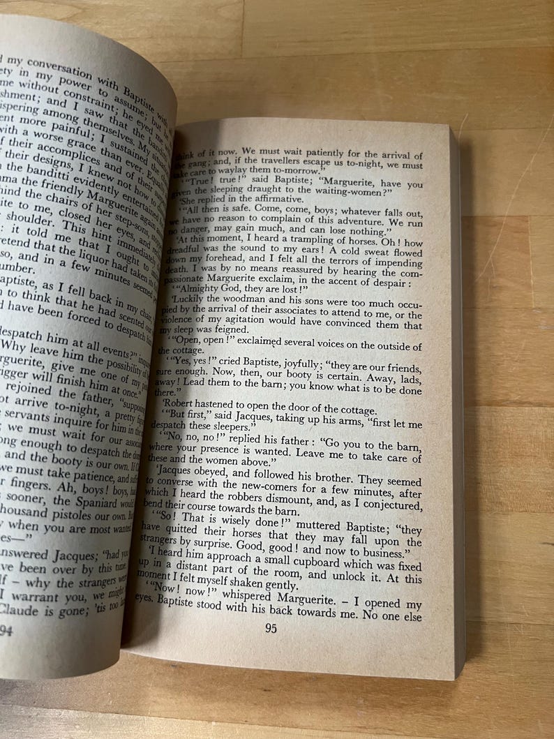 May include: Open book pages with text, featuring the numbers 94 and 95. The text appears to be from a novel, with a vintage aesthetic. The pages are slightly yellowed, suggesting age.
