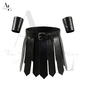 May include: Black leather skirt with a belt and buckle, featuring vertical strips. Includes two matching black leather arm cuffs. The skirt has a classic design.