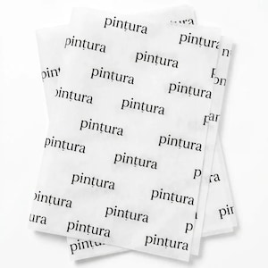 May include: A stack of translucent white tissue paper sheets featuring a repeating pattern of the word "pintura" printed in a black serif font. The lightweight paper is layered, creating a semi-transparent effect with the text visible throughout.