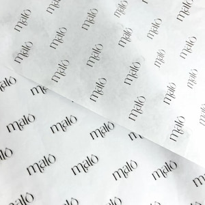 May include: A sheet of thin, semi-translucent white tissue paper featuring a repeating pattern of the word malo printed in a black serif font. The paper is layered, showing multiple sections of the branded material with a soft, creased texture.