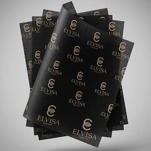 Könnte beinhalten: Ein Stapel schwarzer Seidenpapierbögen mit einem sich wiederholenden goldenen Logomuster. Jedes Logo besteht aus einem stilisierten Buchstaben C mit einem floralen Emblem darin, gefolgt vom Text ELVISA COSMETICS in Serifenschrift.