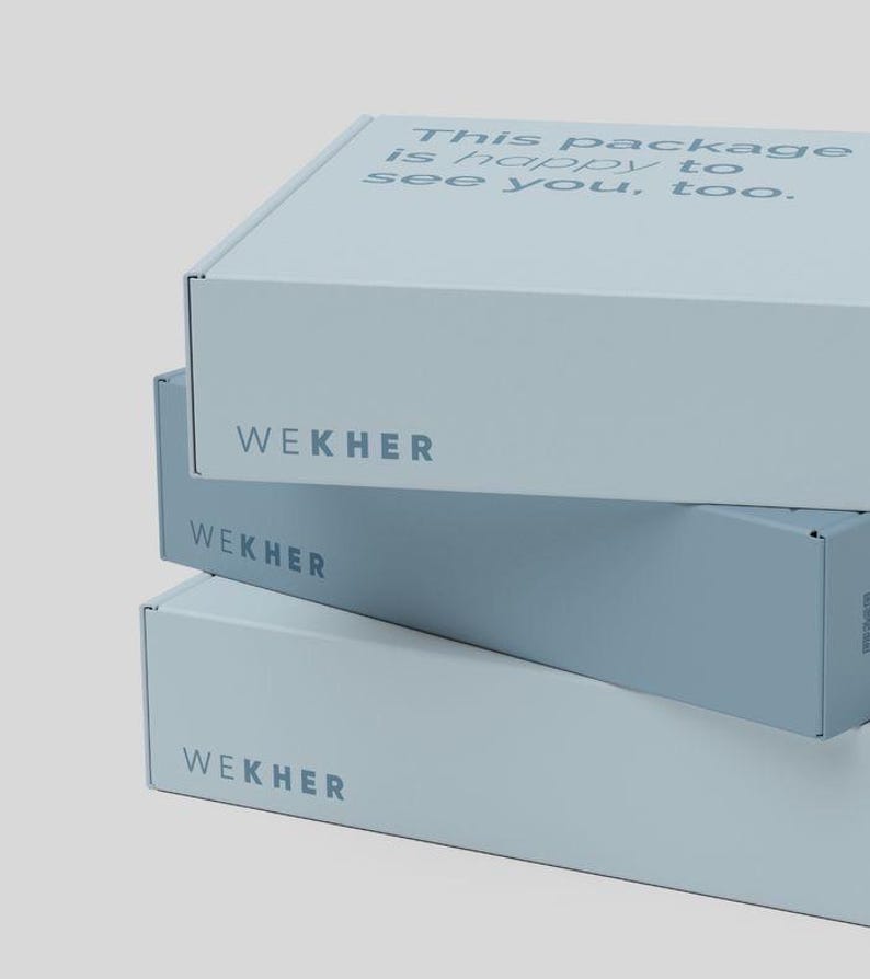 May include: A stack of three light blue rectangular cardboard shipping boxes. Each box features the brand name WEKHER printed in dark blue on the front side. The top box has the text This package is happy to see you, too. printed on its lid.