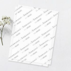 May include: A stack of translucent white tissue paper sheets featuring a repeating diagonal pattern of the grey text YOUR LOGO HERE. The paper is thin and semi-transparent, displaying the repeated branding text across the entire surface area.
