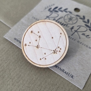 Puede incluir: Una taza de cerámica blanca con asa negra y el texto "But First, Coffee" en negro, con una fuente de estilo manuscrito. La taza está sobre una superficie blanca.