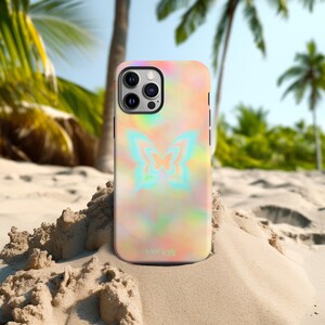 Peut inclure: Une coque de smartphone avec un motif tie-dye coloré et un papillon. La coque présente une palette de couleurs pastel avec des teintes roses, jaunes et bleues. Le texte "LADY GAGA" est imprimé en bas.