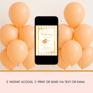 May include: A smartphone displays a birthday invitation with the text "Victoria is turning one" and an orange graphic. Peach-colored balloons surround the phone. The invitation has a striped background and bow accents.