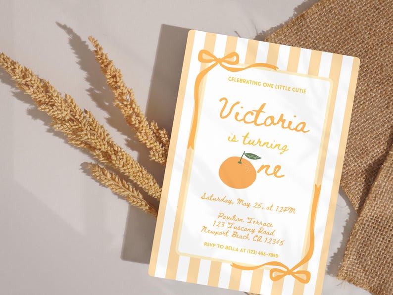 May include: A birthday invitation with a light orange and white striped background. The invitation features the text "Victoria is turning one" with an orange illustration. The invitation also includes event details and RSVP information.