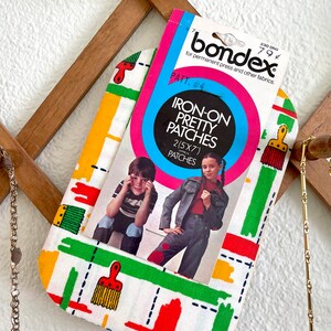 May include: A package of iron-on patches with a white background and colorful paintbrush designs. The package includes instructions for using the patches and a photo of two children wearing clothing with the patches. The package is labeled "Iron-On Pretty Patches" and "2 (5x7) Patches".