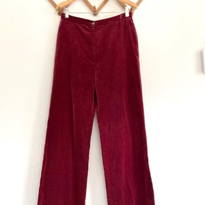 Puede incluir: Un pantal&oacute;n de pierna ancha en color burdeos oscuro. El pantal&oacute;n est&aacute; hecho de una tela suave y aterciopelada y tiene una cintura alta.