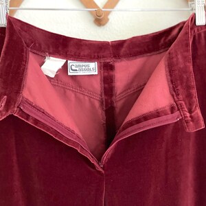 Puede incluir: Un pantal&oacute;n de terciopelo burdeos con cierre de cremallera y una etiqueta que dice "Campus Casuals of California".