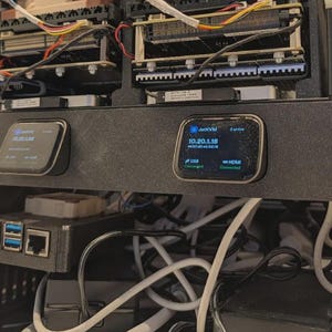 May include: A black rack-mount panel featuring two JetKVM display modules with digital screens showing IP addresses 10.20.1.22 and 10.20.1.18, with USB and HDMI connection status indicators, positioned below server hardware and above a tangle of white cables.