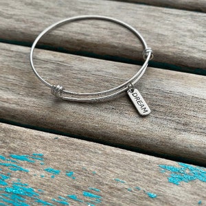 Dream Bracelet-  laser engraved charm on a stainless steel adjustable bangle bracelet
