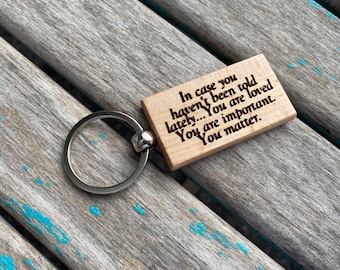 May include: Wooden keychain with a silver ring and a message that reads: "In case you haven't been told lately... You are loved. You are important. You matter."