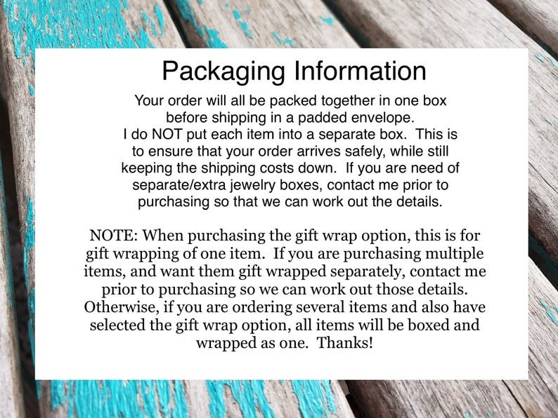 May include: Text on a blue and white wooden background explaining packaging information for orders. The text states that orders are packed together in one box and shipped in a padded envelope. It also explains that the seller does not put each item in a separate box to ensure the order arrives safely and to keep shipping costs down. The text also explains that if you need separate jewelry boxes, you should contact the seller prior to purchasing. The text also explains that the gift wrap option is for one item only and that if you are purchasing multiple items and want them gift wrapped separately, you should contact the seller prior to purchasing. The text also explains that if you are ordering several items and have selected the gift wrap option, all items will be boxed and wrapped as one. The text ends with "Thanks!"