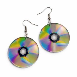 May include: A pair of earrings crafted from iridescent CDs. Each earring showcases a circular CD with a rainbow sheen, suspended from a silver-coloured fish hook. The earrings have a black centre hole and a reflective surface.