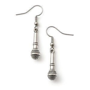 May include: A pair of silver-toned earrings shaped like vintage microphones. Each earring features a hook, a detailed microphone body, and a textured, rounded head. The earrings are displayed against a white background.
